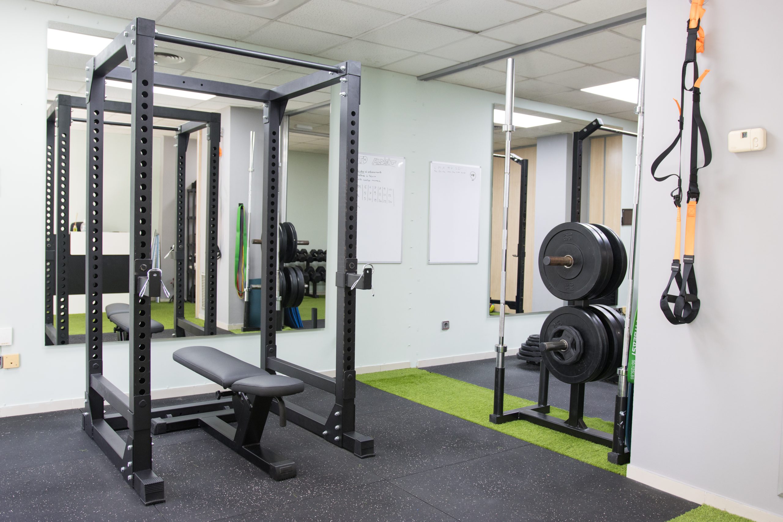 Sala de ALDIFIT con rack, banco, discos y material de suspensión